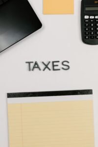 Calculadora e bloco de notas em foto de arquivo de 2021, para contexto tributário; não registra atendimento ou formulário da Receita Federal.