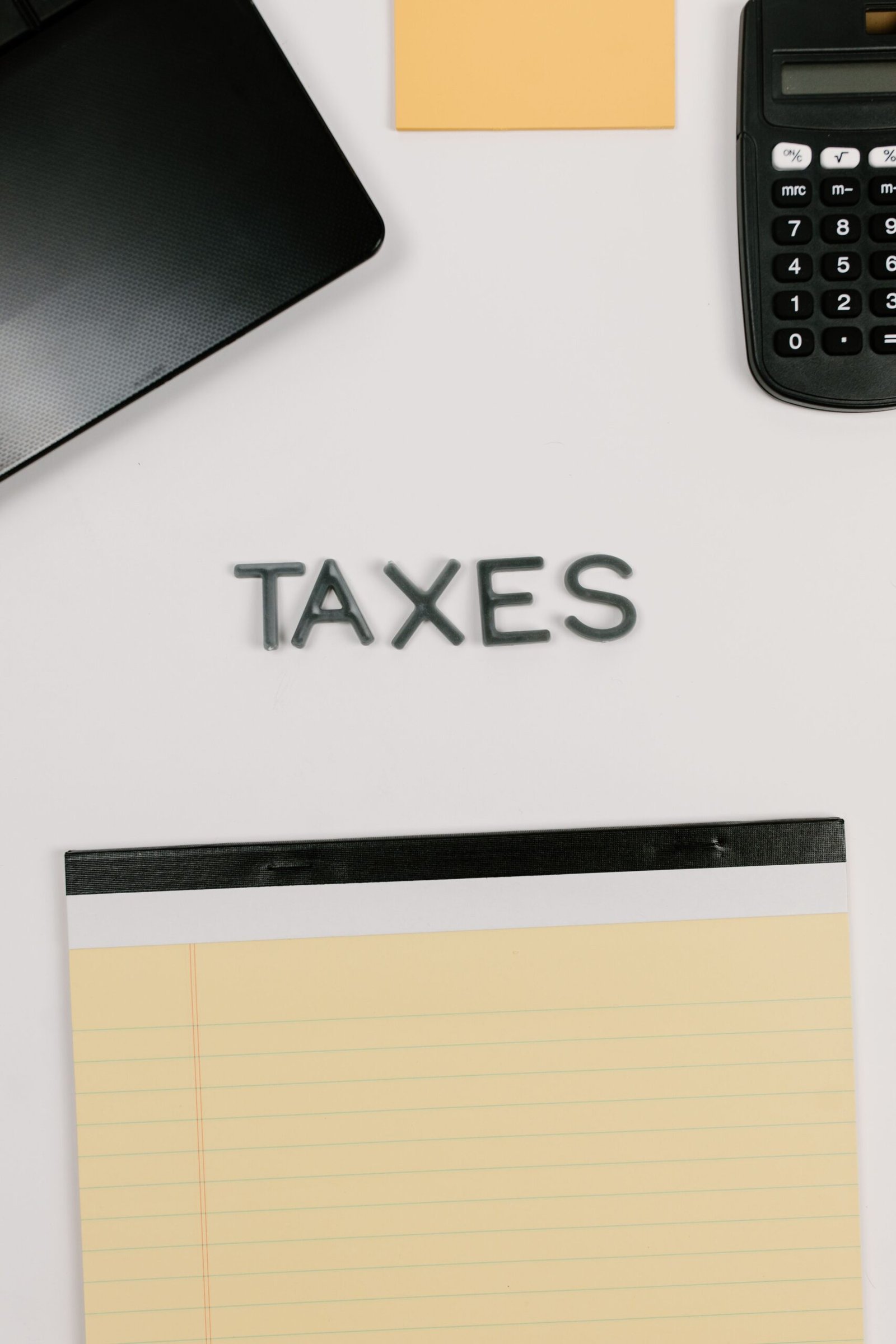 Calculadora e bloco de notas em foto de arquivo de 2021, para contexto tributário; não registra atendimento ou formulário da Receita Federal.